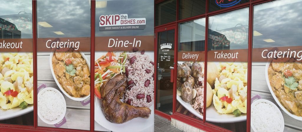 Photo shared on Ocho Rios Caribbean Eatery's website showing the storefront window with menu photos and the restaurant's name.